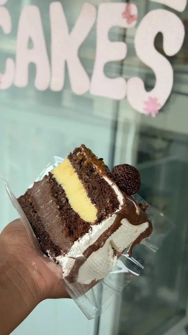 Fatia de bolo em camadas com recheio e cobertura de chocolate