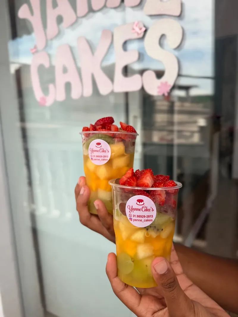 Dois copinhos com frutas picadas e morangos